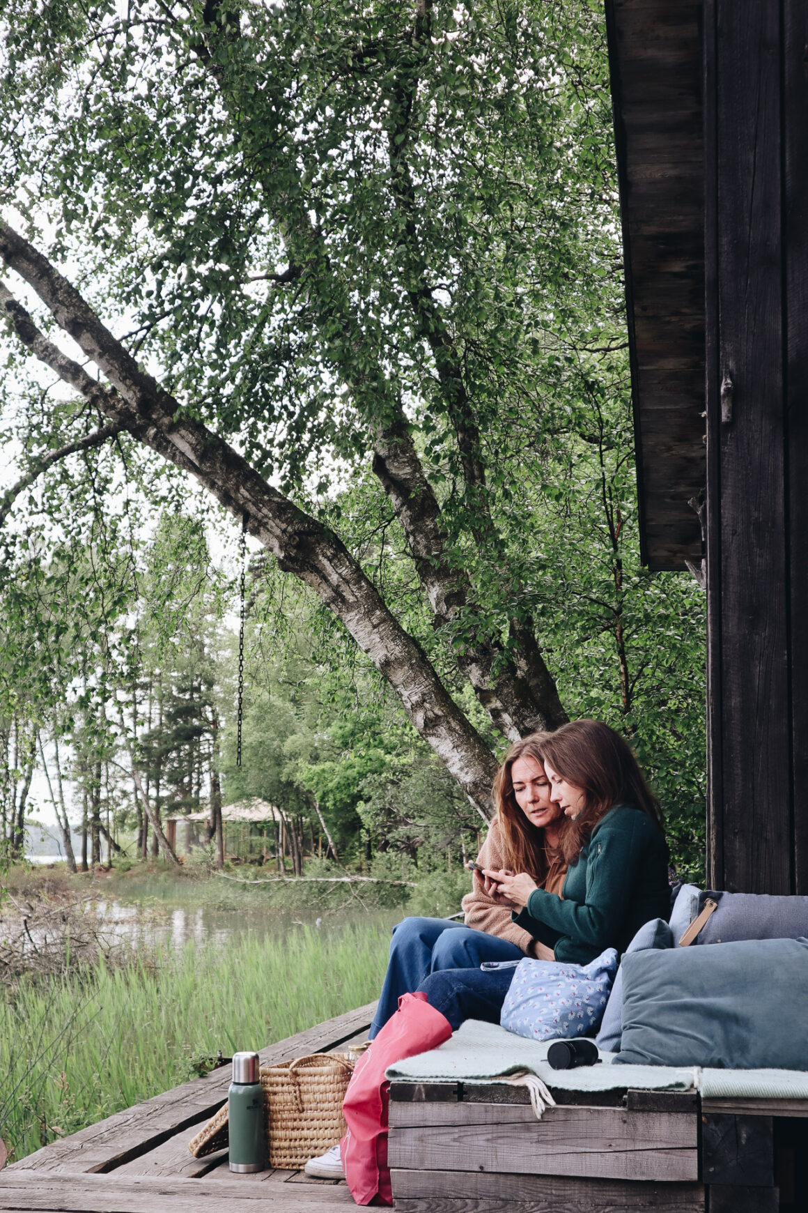två kvinnor på en bänk vid en sjö i halland